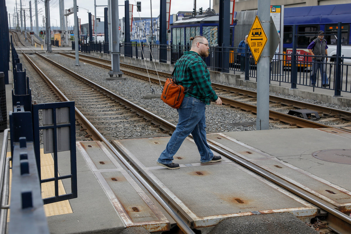 Matthew with a Burnt Orange Pilot, walking through a Light Rail station