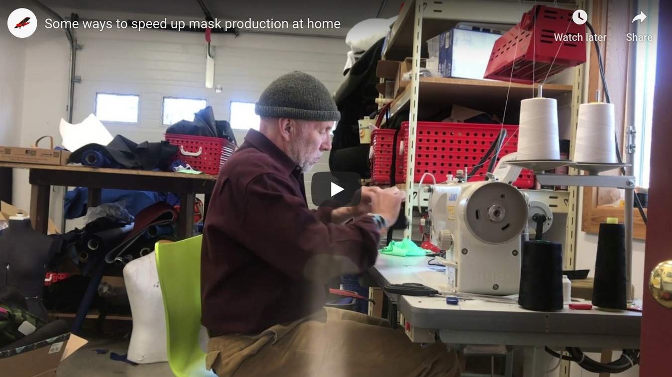 A person sitting at a sewing machine to sew masks.