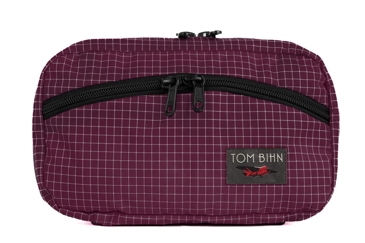 visible variant TB0419-5D^^The front of a Handy Little Thing #2 in Acai (purple with white grid) 200 Halcyon showing the front zipper with two slider and logo at the bottom-right corner.