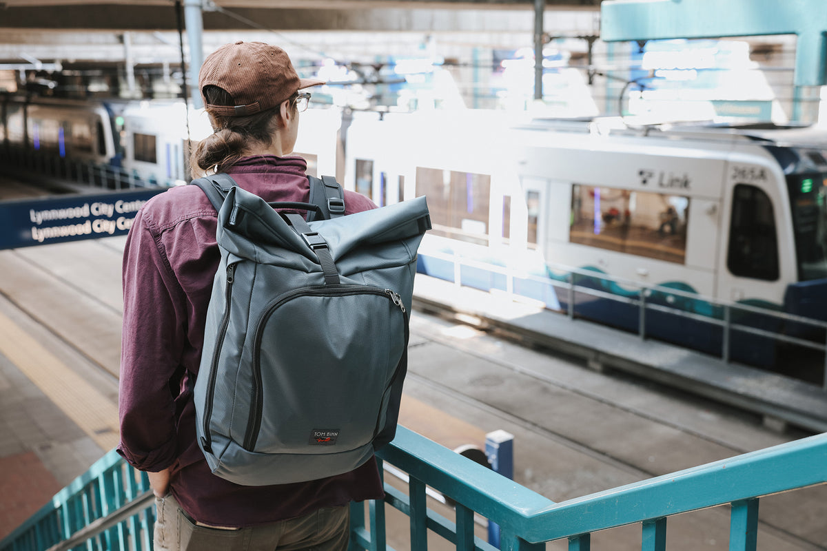 visible lifestyle^^A person going down stairs into a light rail station wearing the Adept