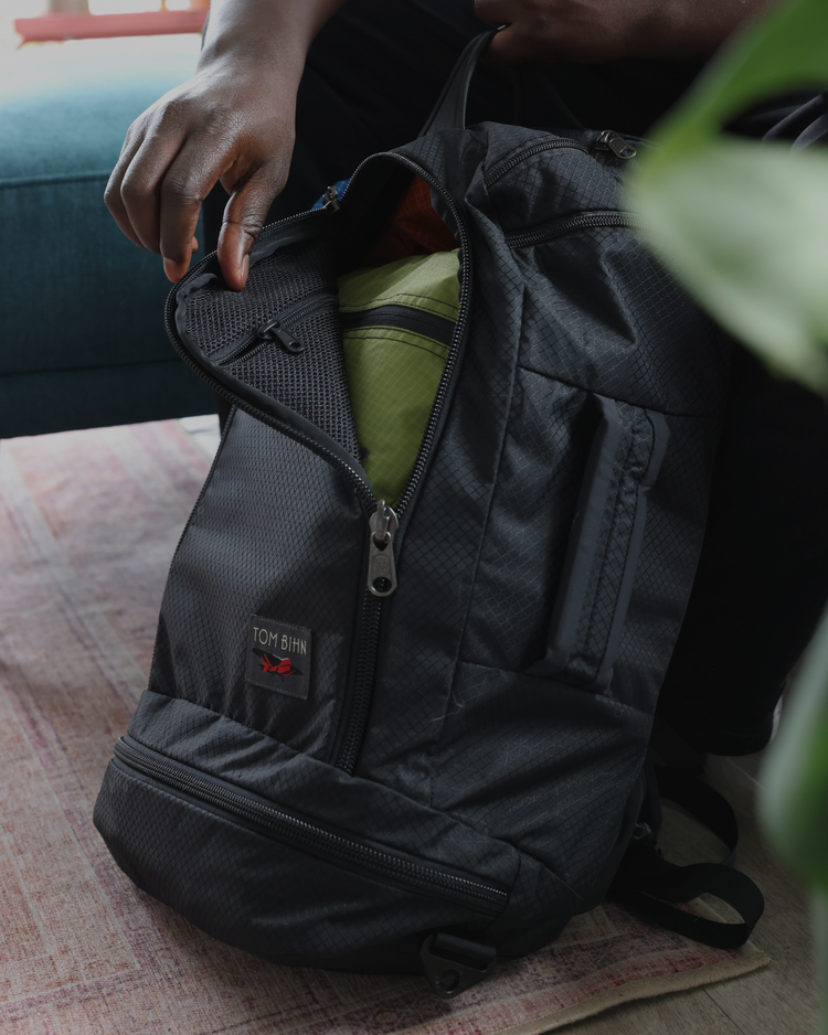 Person unzipping Techonaut 45 in Black Spectron