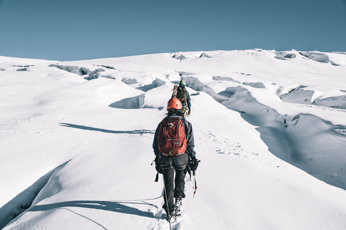 lifestyle visible^^Person hiking with Guide's Edition Synik 30 through snowy terrain.