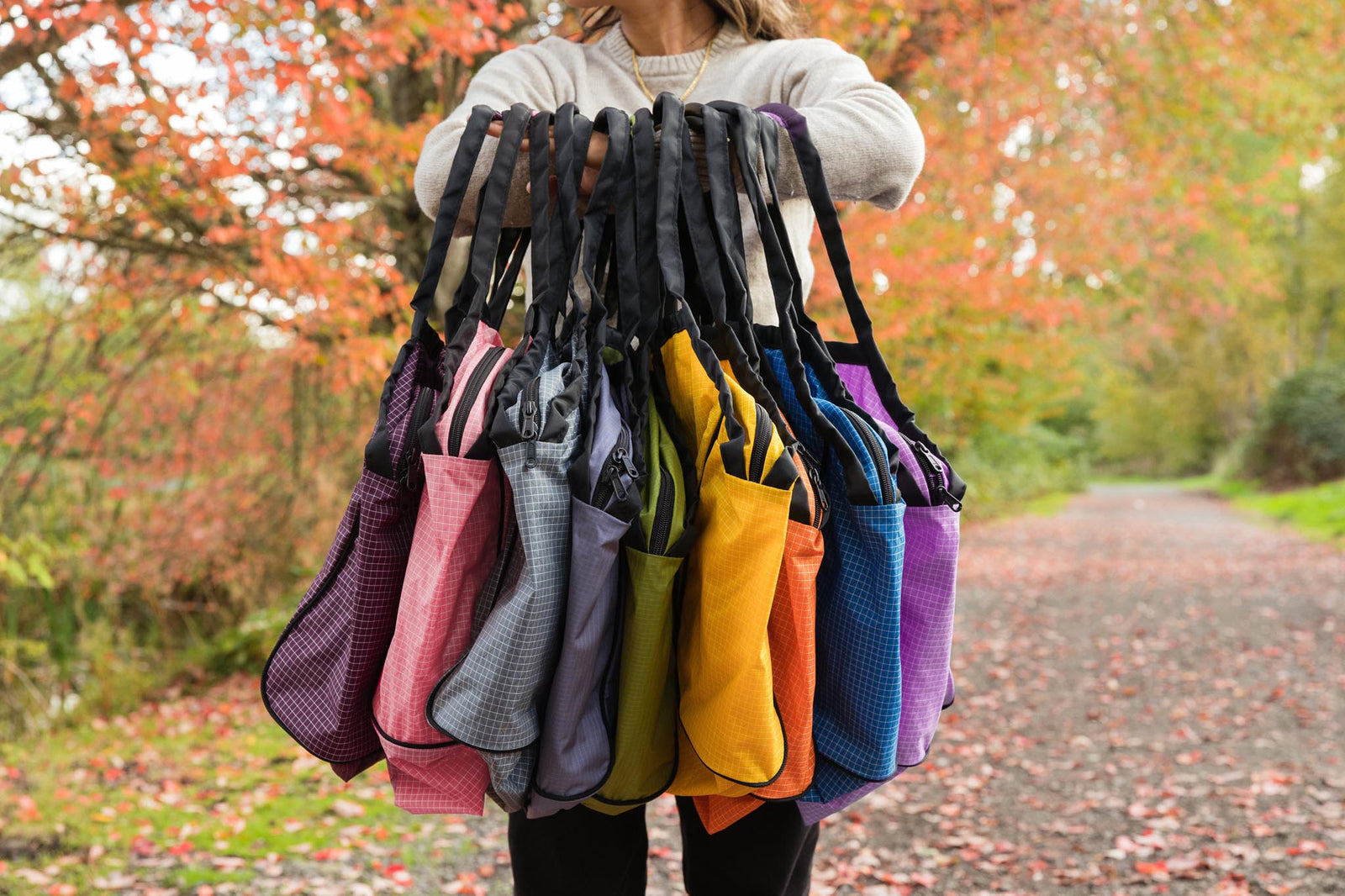 visible lifestyle^^A person holding all the Large Zip-Top Shop Bags.