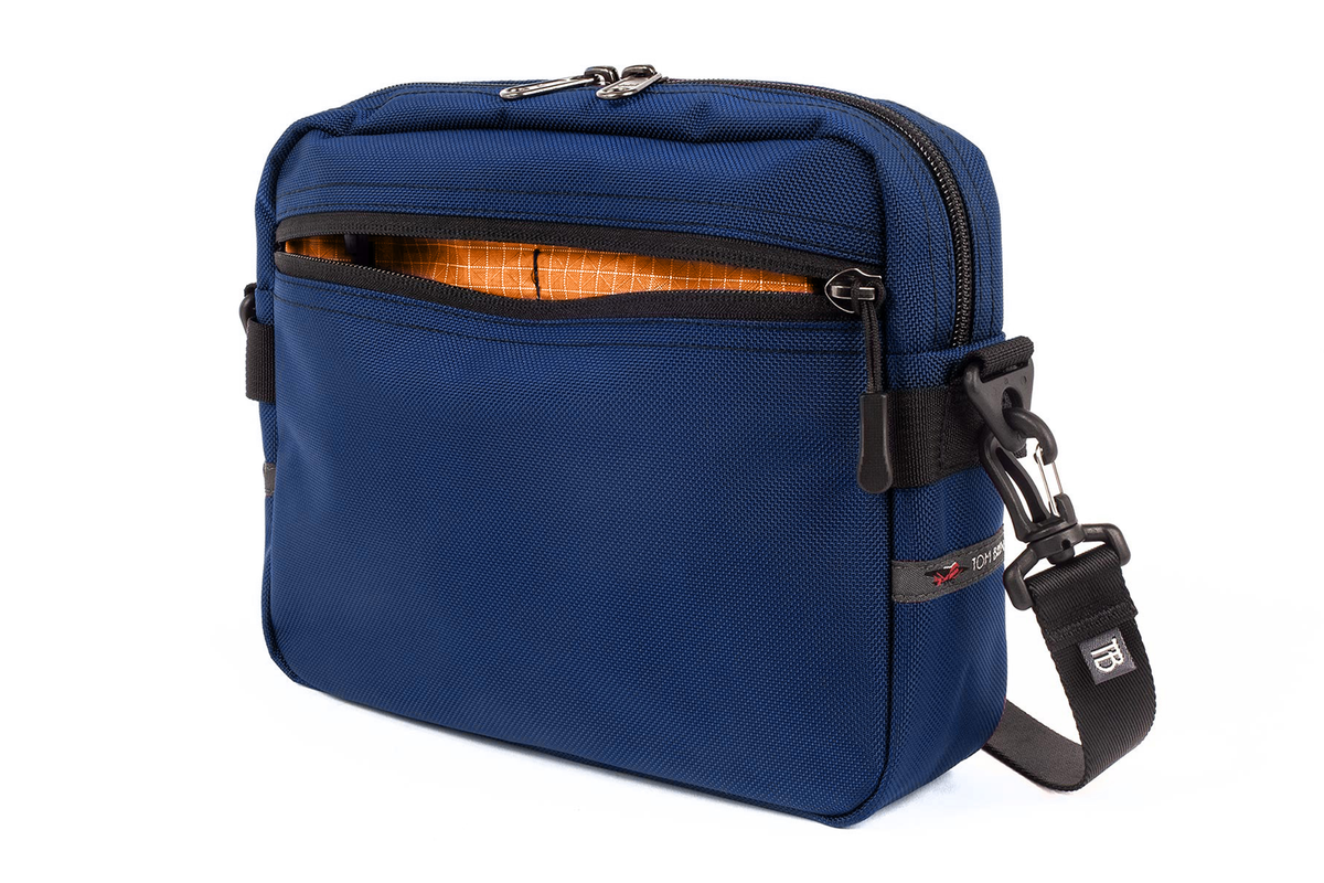 visible variant TB0414-DKZD^^The Side Kick in Deep Blue (midnight blue) Ballistic with Zest (orange with white grid) 200 Halcyon interior.