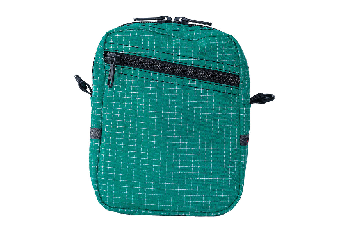 visible variant TB0416-EDGE^^An Everyday Cubelet in Kelpie Halcyon (bluish-green with a white grid) with a front zipper.