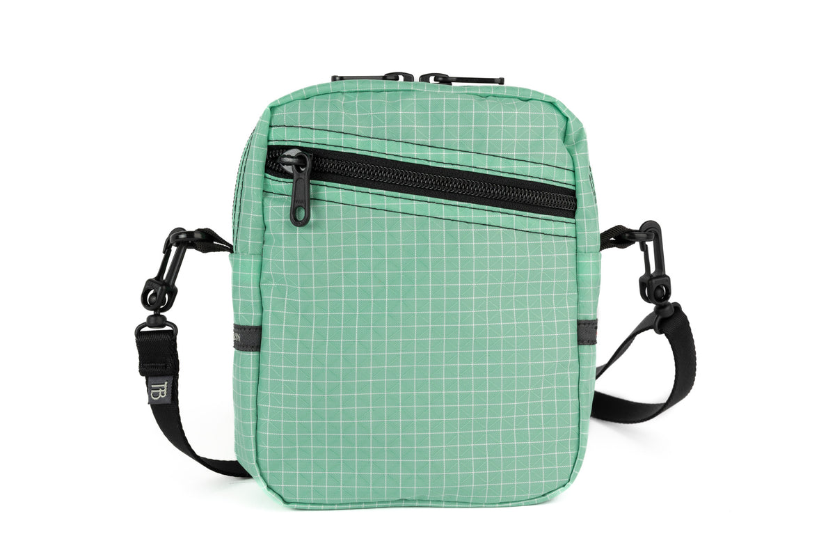 visible variant TB0416-GDGE^^An Everyday Cubelet in Seafoam Halcyon (green with a white grid) with a front zipper.
