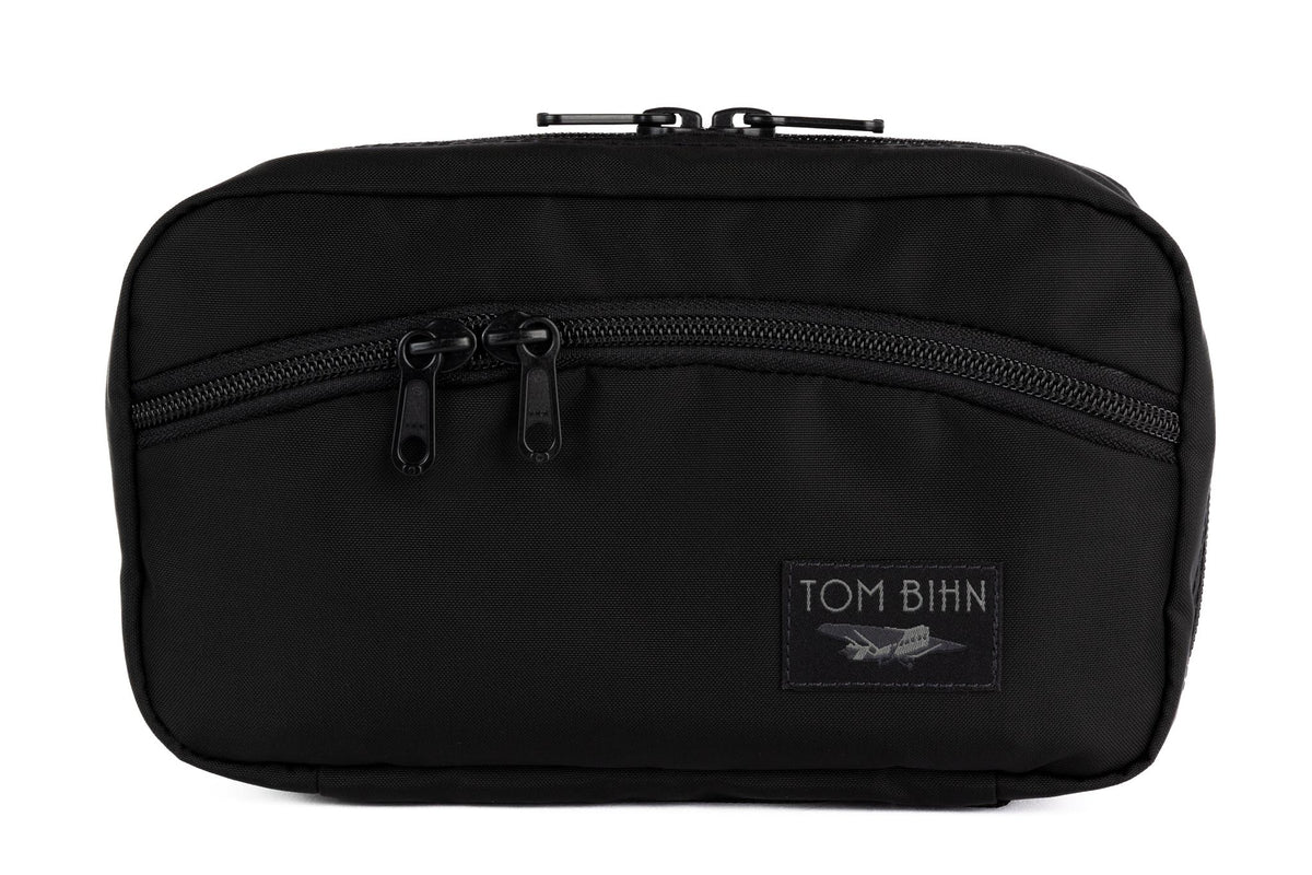 visible variant TB0419-BJ TB0419-BN^^The front of a Handy Little Thing #2 in Black 210 Ballistic showing the front zipper with two slider and logo at the bottom-right corner.