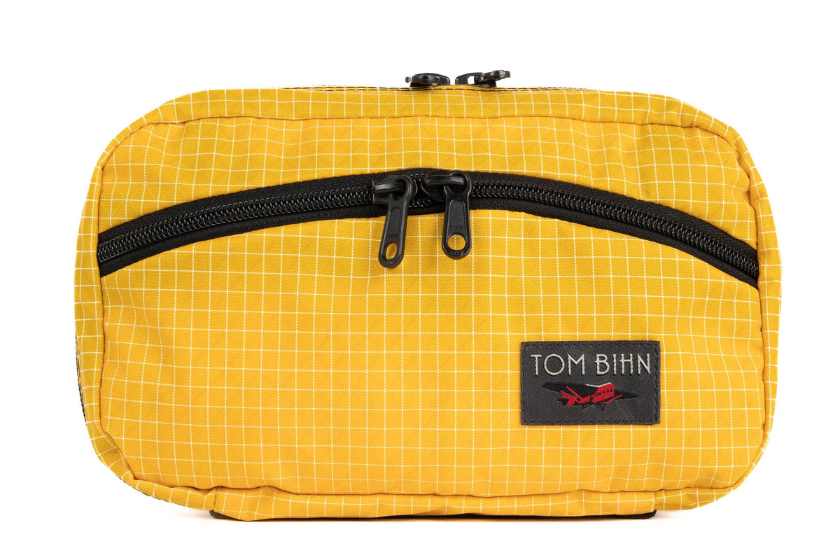 visible variant TB0419-OD^^The front of a Handy Little Thing #2 in Solaris (yellow) 200 Halcyon showing the front zipper with two slider and logo at the bottom-right corner.
