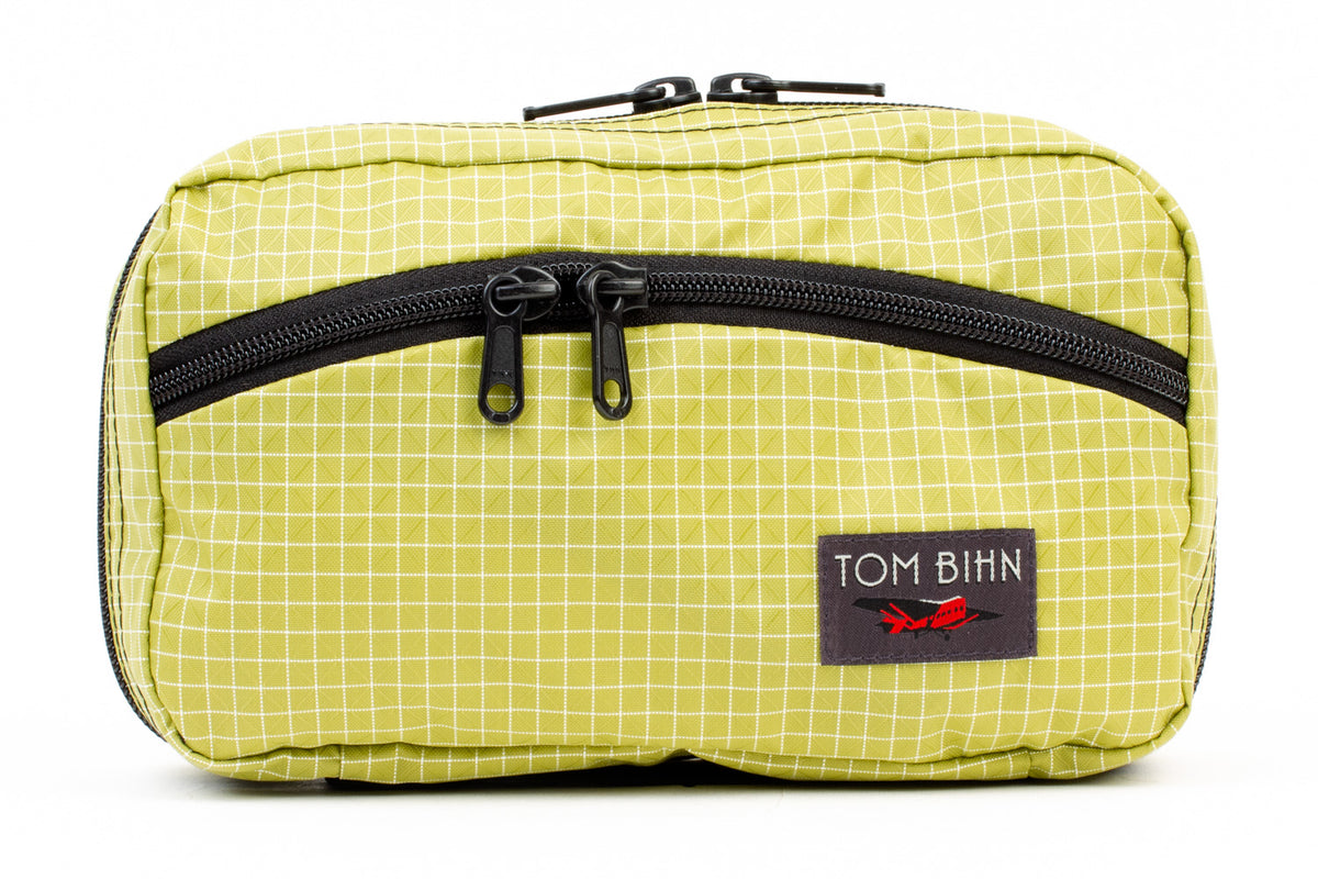 visible variant TB0419-WD^^The front of a Handy Little Thing #2 in Wasabi (green) 200 Halcyon showing the front zipper with two slider and logo at the bottom-right corner.