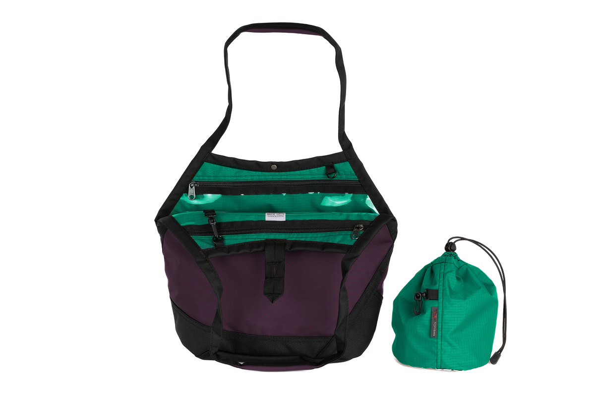 visible variant TB0660-UKEL^^The Swift in Aubergine Ballistic with a Emerald (green with dark green grid) interior and Medium Yarn Stuff Sack