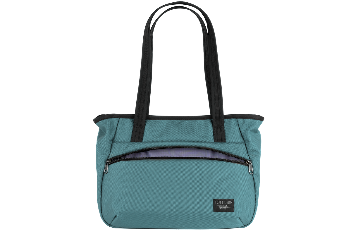 visible variant TB0715-KKDL^^Photo of the Nomad Tote in Agave (pale blue) Ballistic with Dusk (purplish-blue with light purplish-blue grid) 210 Cerylon interior.