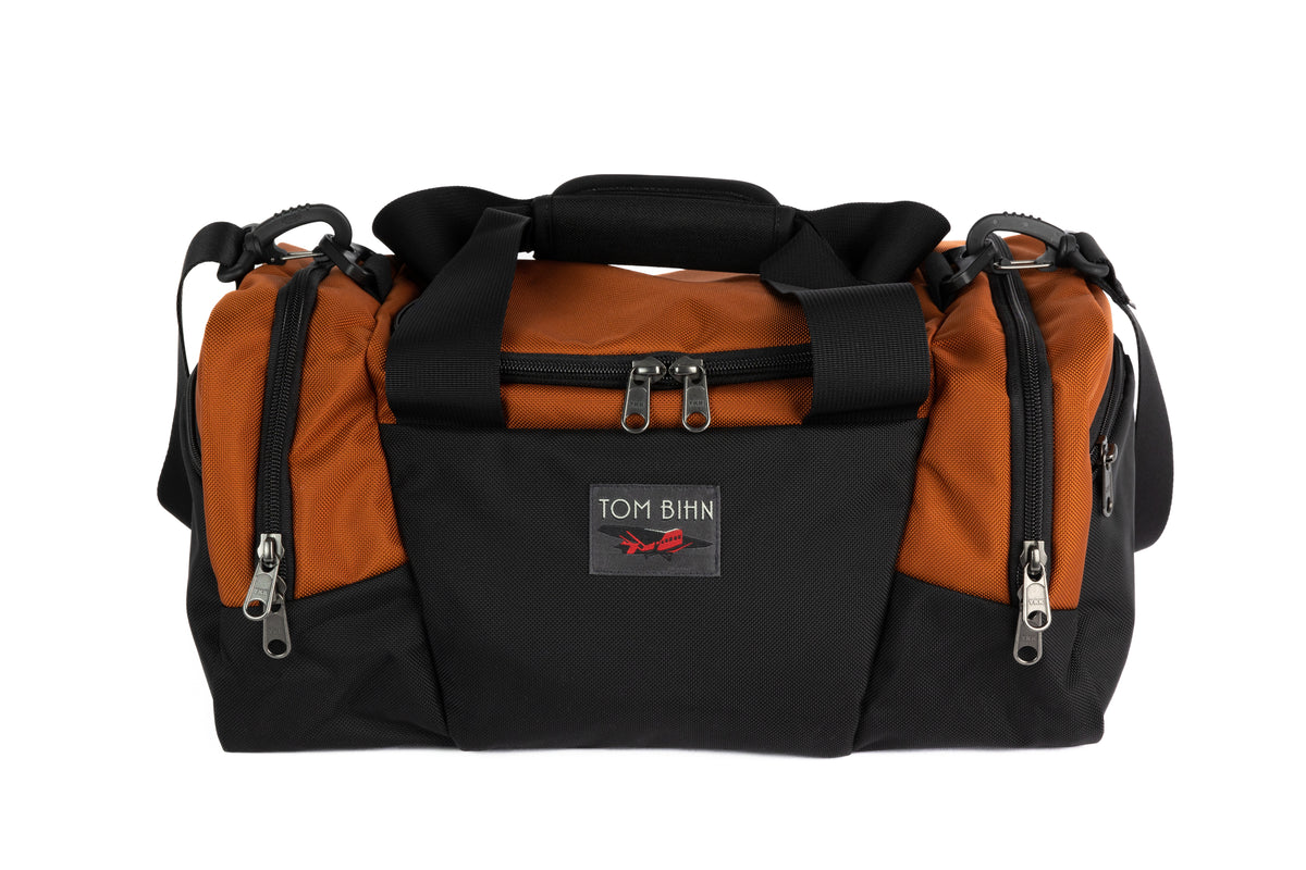 visible variant TB0904-TKGL^^The Night Flight Travel Duffel in Burnt Orange Ballistic.