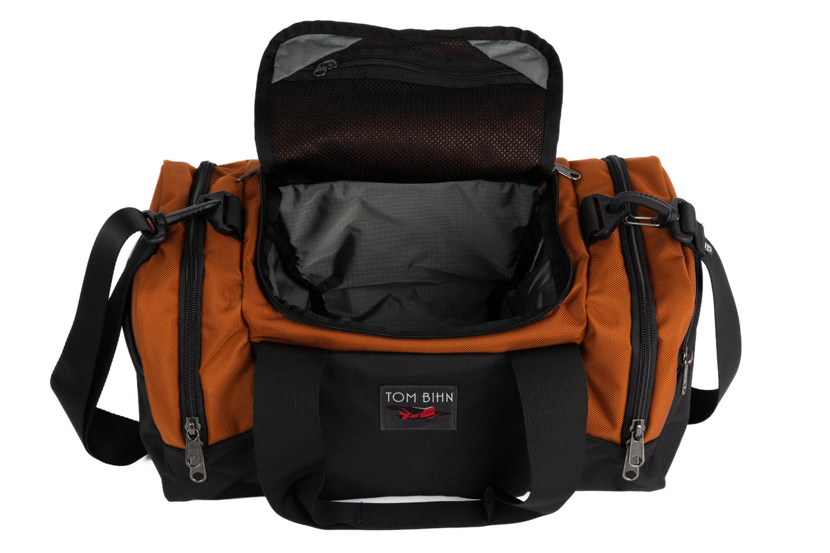 visible variant TB0904-TKGL^^The Night Flight Travel Duffel in Burnt Orange Ballistic with a Mountain Grey 210 Cerylon interior.