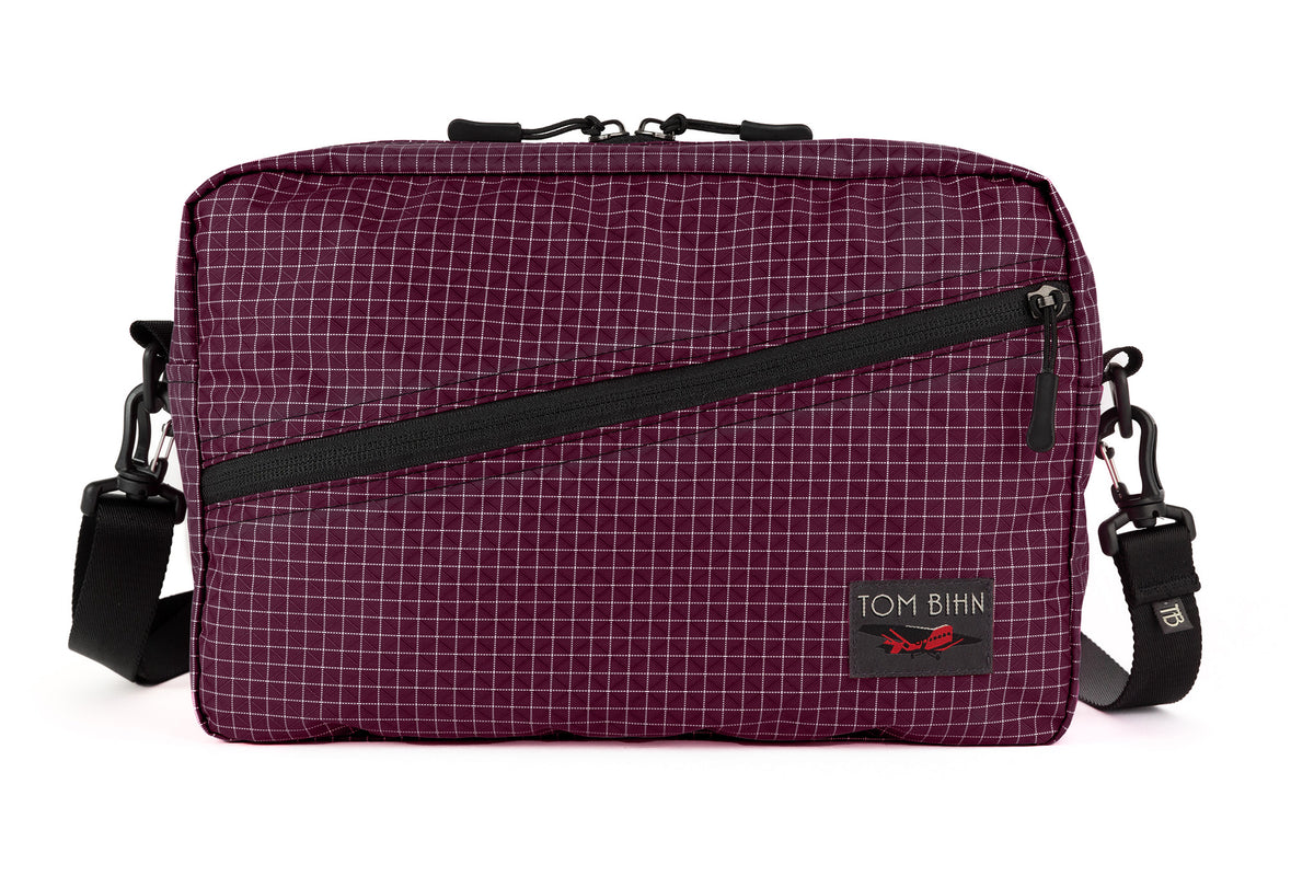 visible variant TB0921-5D^^A Packing Cube Shoulder Bag in Acai (dark purple with white grid) 200 Halcyon with a shoulder strap attached