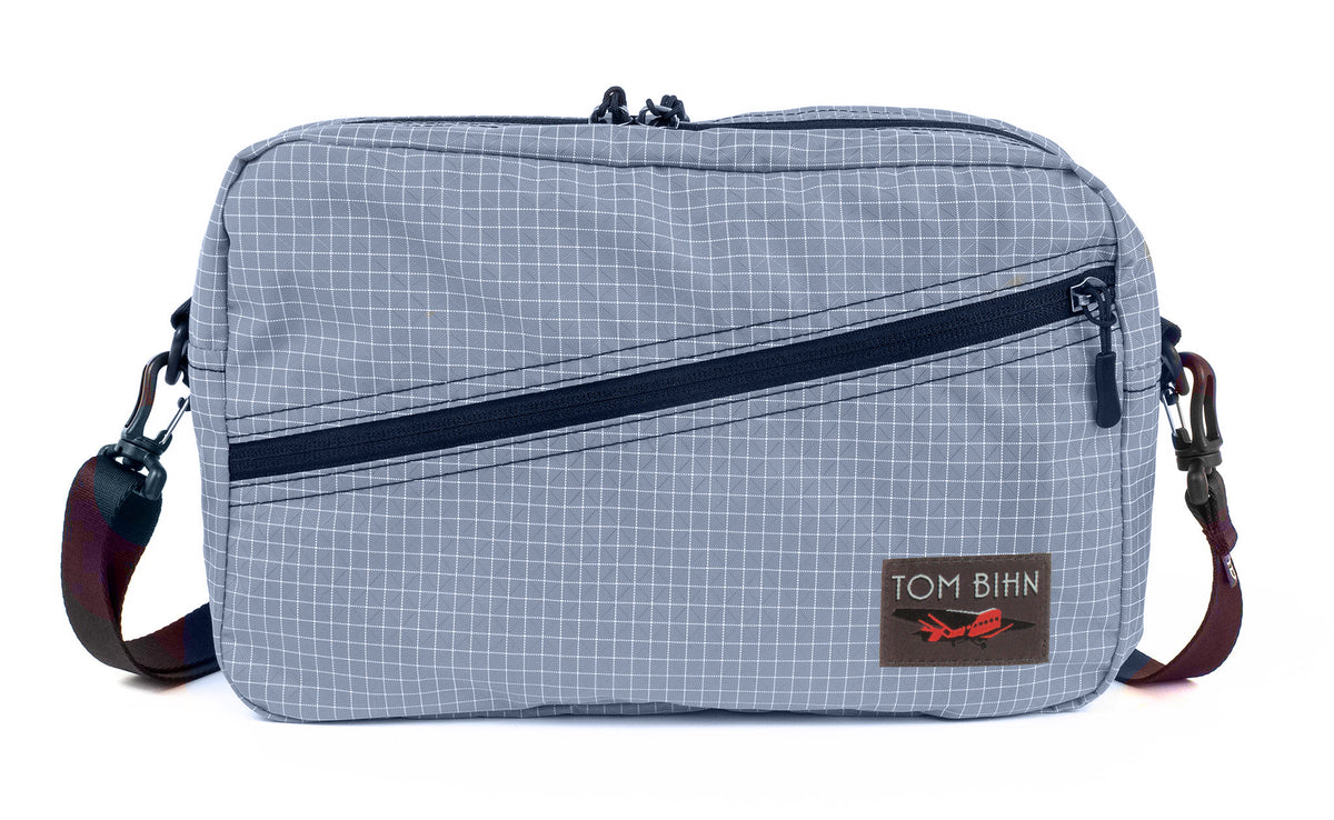 visible variant TB0921-ND^^A Packing Cube Shoulder Bag in Northwest Sky (light grey with white grid) 200 Halcyon with a 1-inch shoulder strap attached.