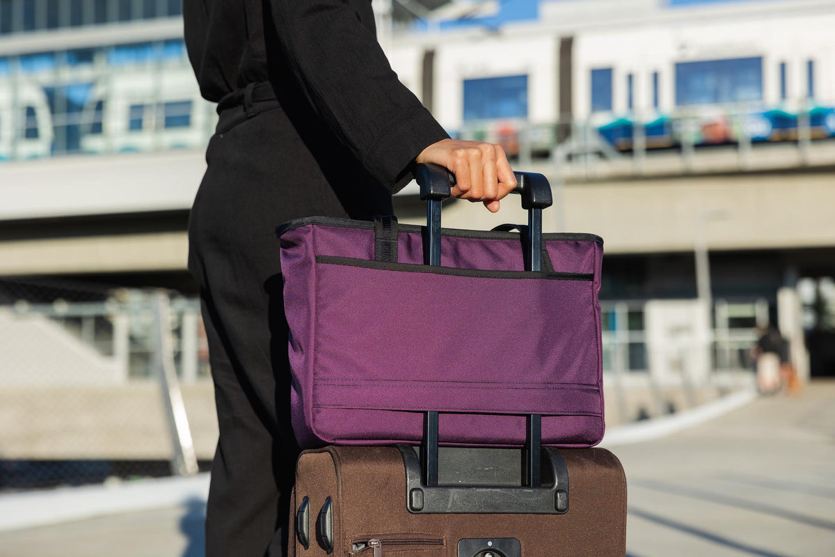 visible lifestyle^^A Nomad attached to rolling luggage using the handle pass-through.
