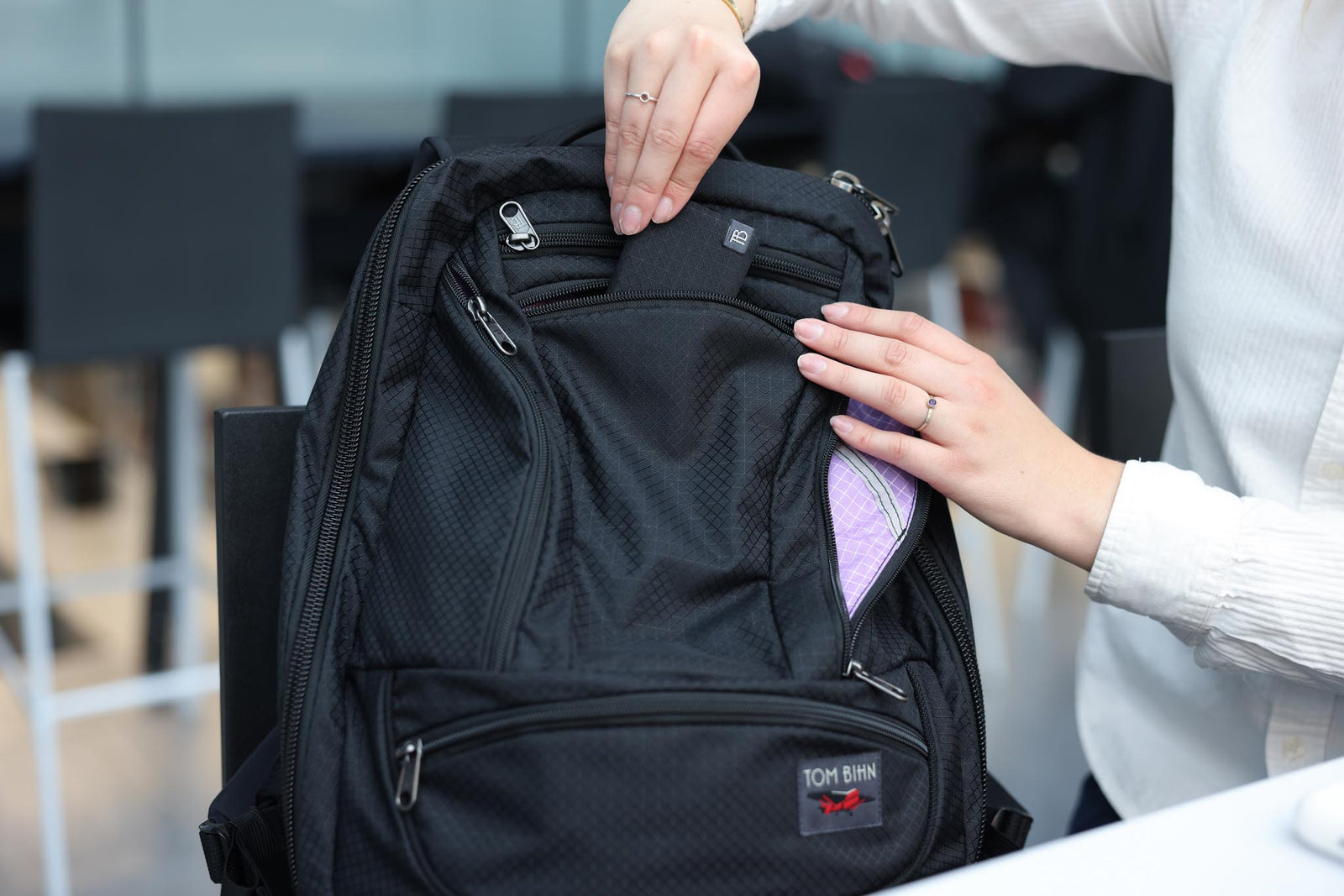 visible lifestyle^^A person putting a Minimalist Wallet into a Synik 30.