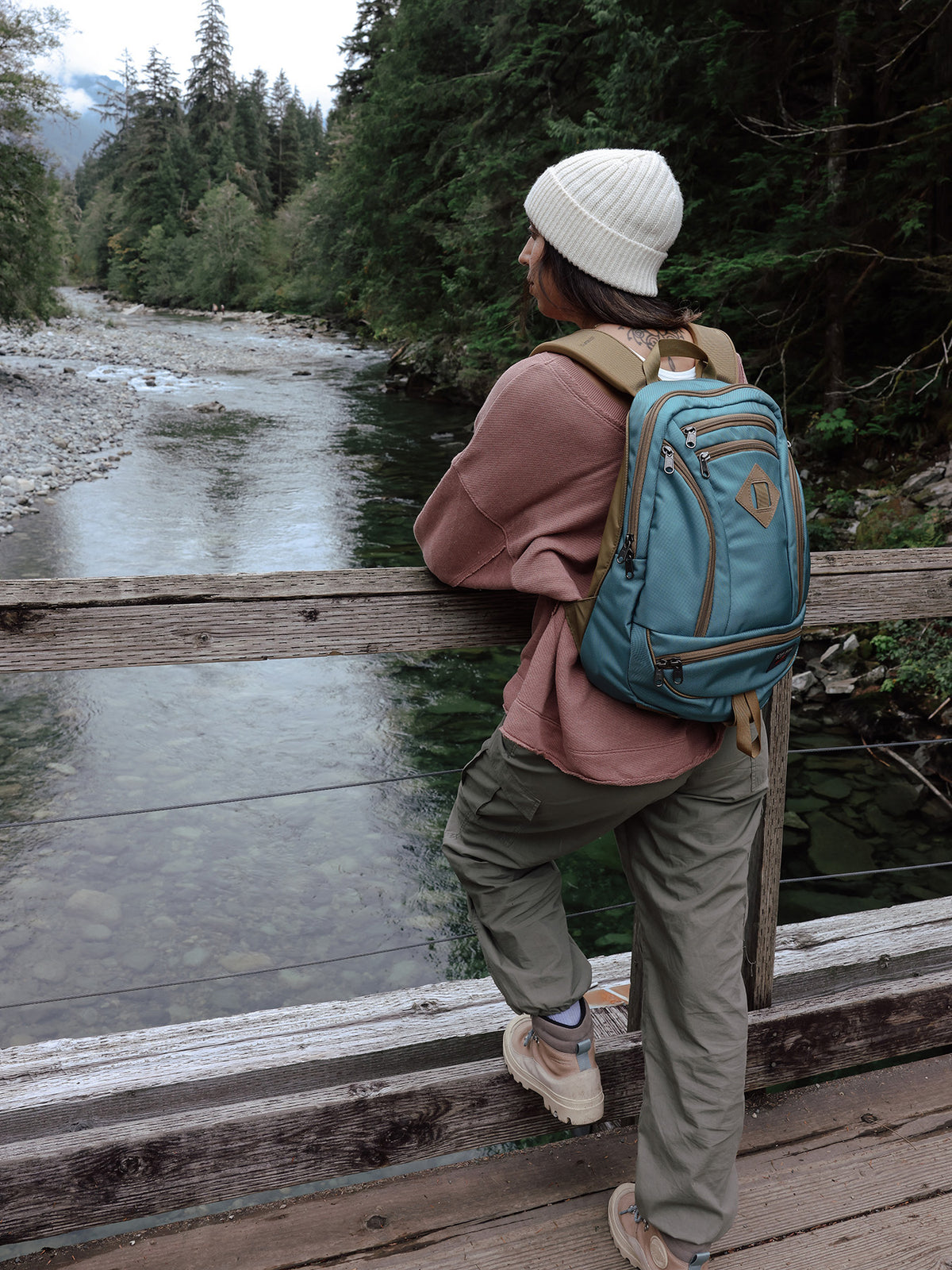 visible lifestyle^^A person carrying a GE Synapse 19 looking over a river on a bridge
