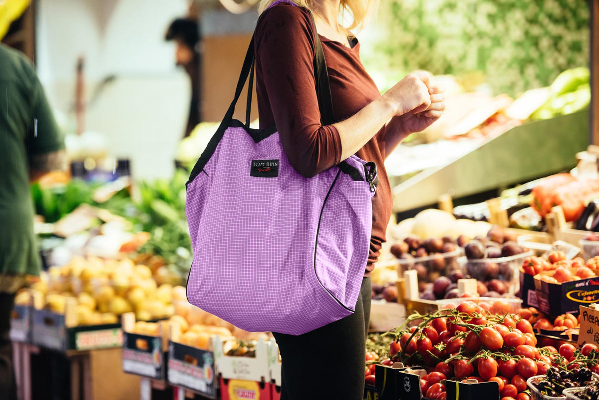 visible lifestyle^^A person holding all the Large Zip-Top Shop Bags.