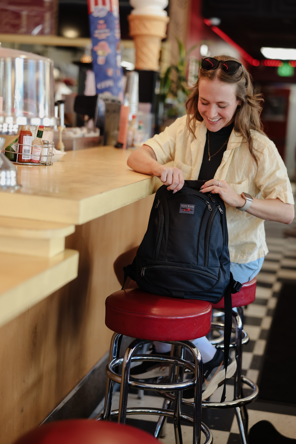 visible lifestyle^^A person accessing a pocket of the Synapse 19 in a diner.