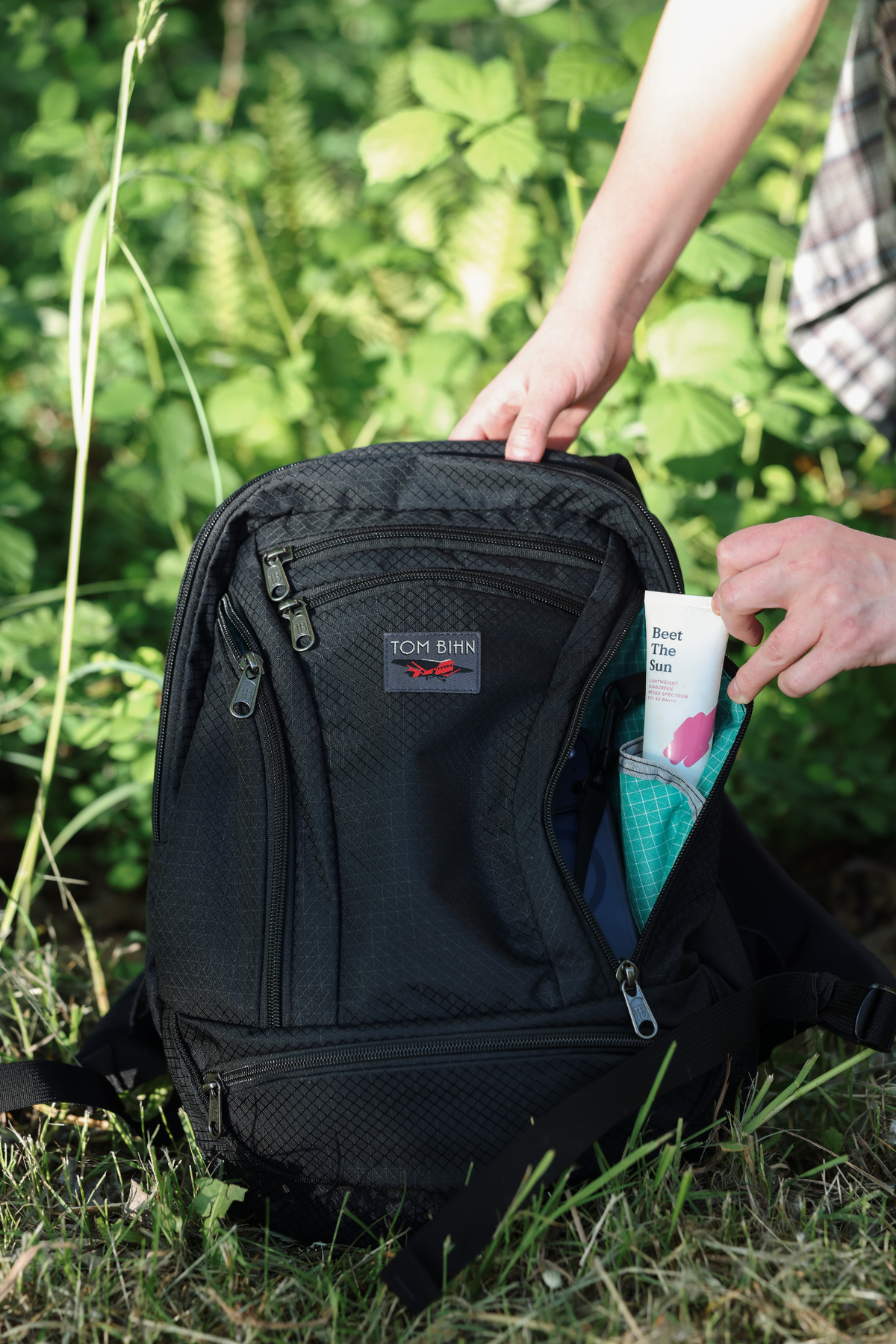visible lifestyle^^A person pulling sunscreen from side pocket of Synapse 19.