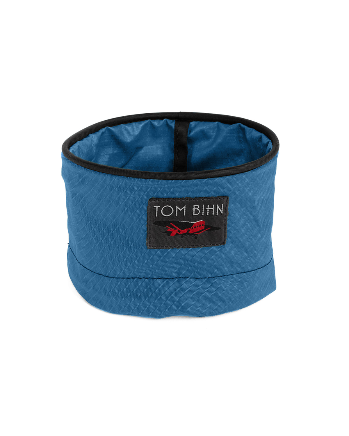 Blue quilted fabric container with black rim and 'Tom Bihn' logo on a white background
