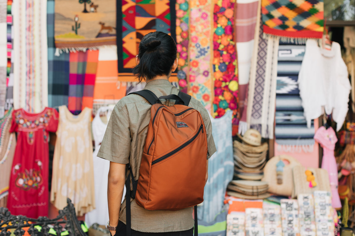 A person wearing the Daylight Backpack while shopping.