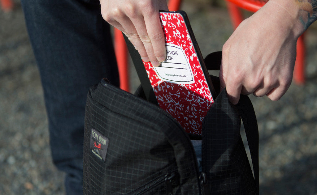 ^^A person removing a notebook from the Daylight Backpack's main compartment