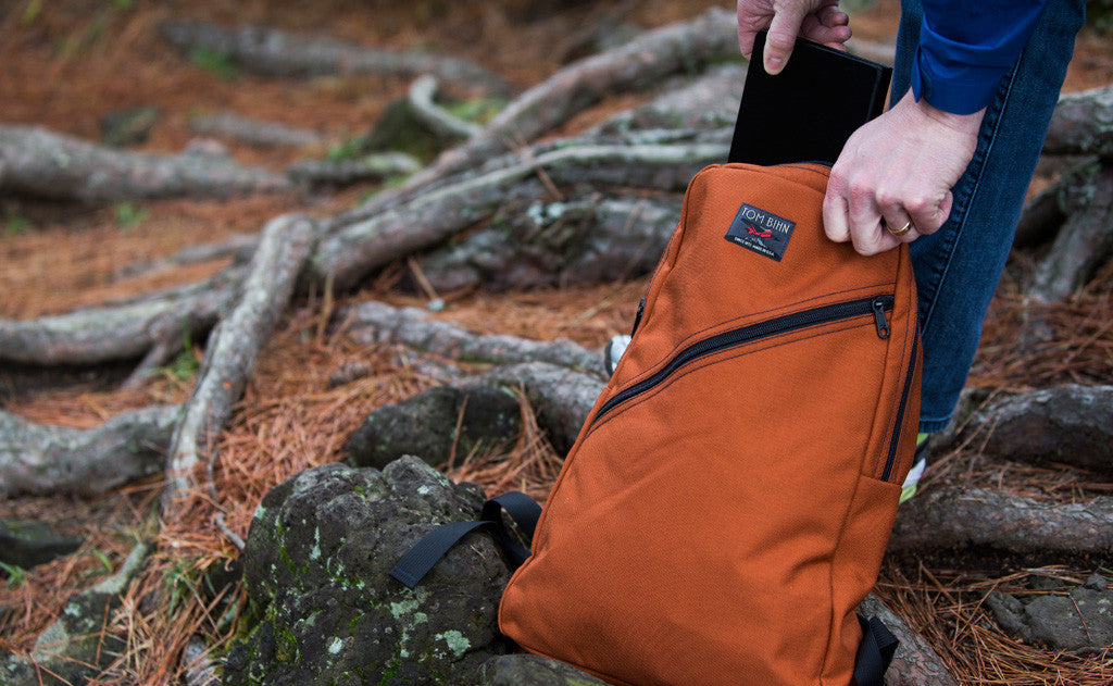 A person accessing the main compartment of the Daylight Backpack