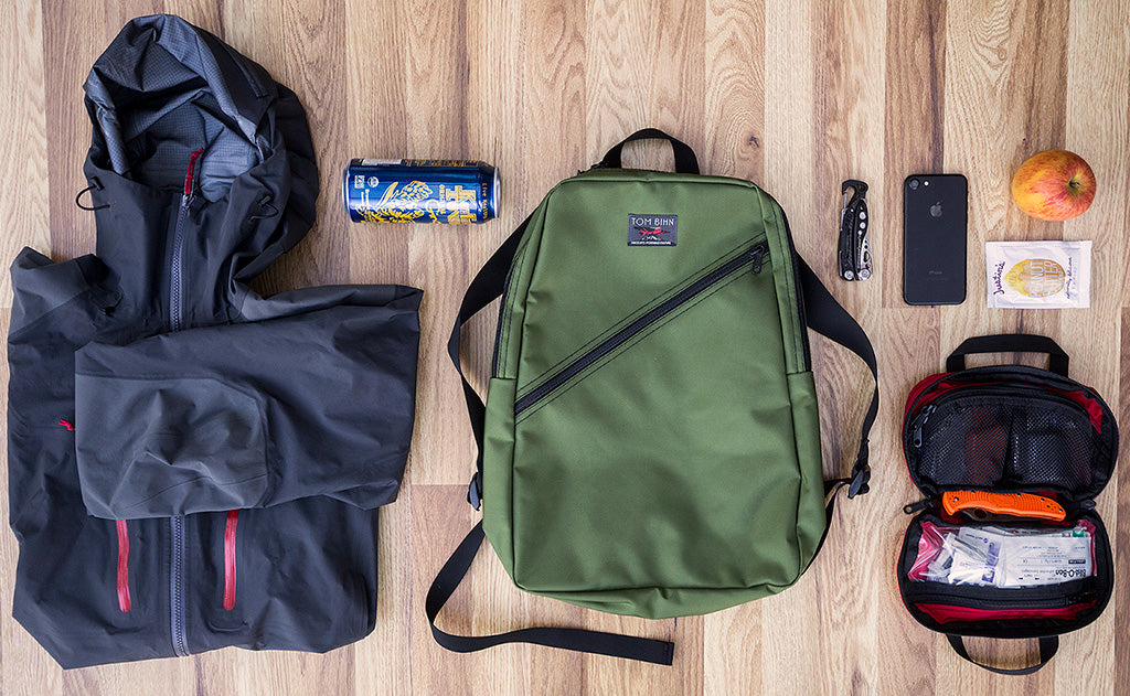 Possible loadout for the Daylight Backpack; a rain shell, soda can, apple, First Aid pouch, multitool and phone