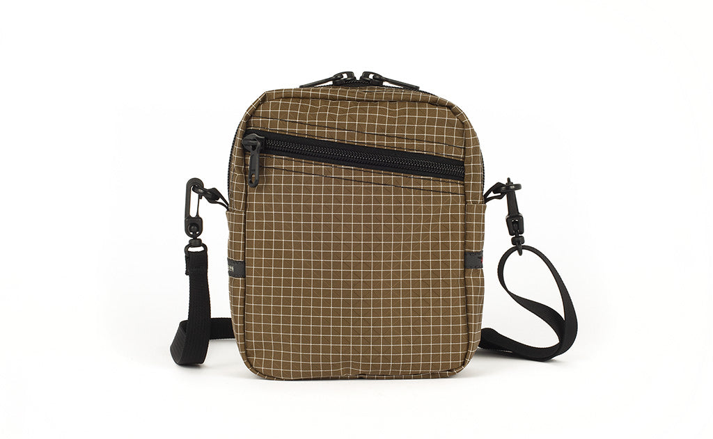visible variant TB0416-CDNE TB0416-CDLE TB0416-CDGE^^An Everyday Cubelet in Coyote Halcyon (brown with a white grid) with a front zipper.