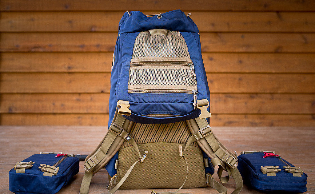 lifestyle visible^^A Guide's Pack with the top flap open to reveal the two mesh zippered pockets.