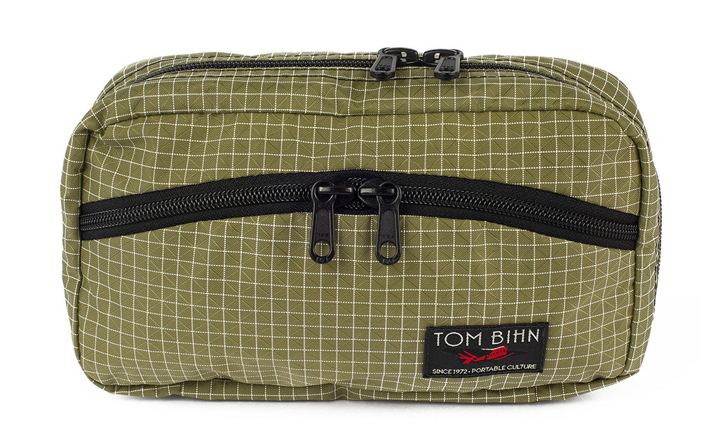visible variant TB0419-8D^^The front of a Handy Little Thing #2 in Taiga (green) 200 Halcyon showing the front zipper with two slider and logo at the bottom-right corner.