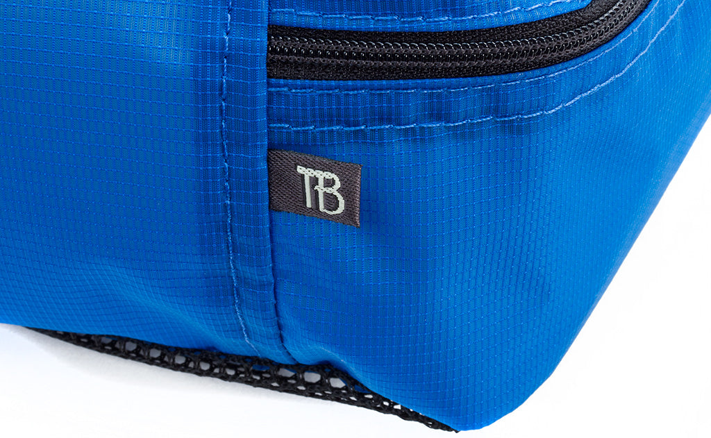 detail visible^^The seam and tab-style TOM BIHN tag on a Western Flyer Packing Cube in Island (blue) 120 Aether.