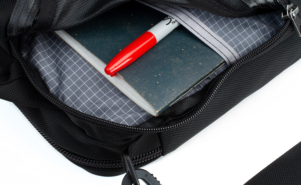 The side compartment of the Pilot with a notepad and marker inserted into the interior pocket.