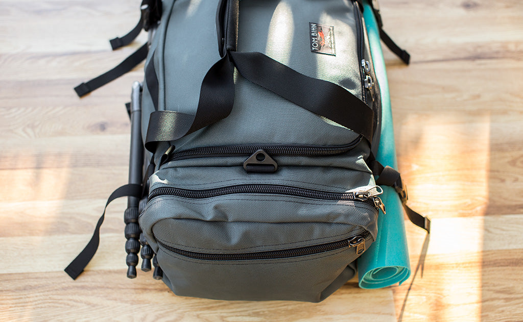lifestyle visible^^The Road Buddy Lash Straps holding a rolled yoga mat and camera tri-pod.