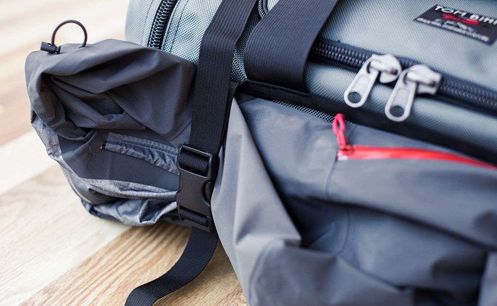 lifestyle visible^^The Road Buddy Lash Straps holding a jacket on a Road Buddy Duffel 60.
