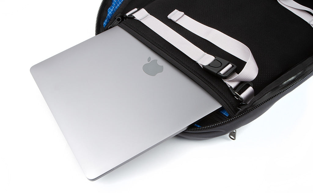 A laptop being removed from the laptop compartment via the zippered opening in the main compartment of the Synik 30. 