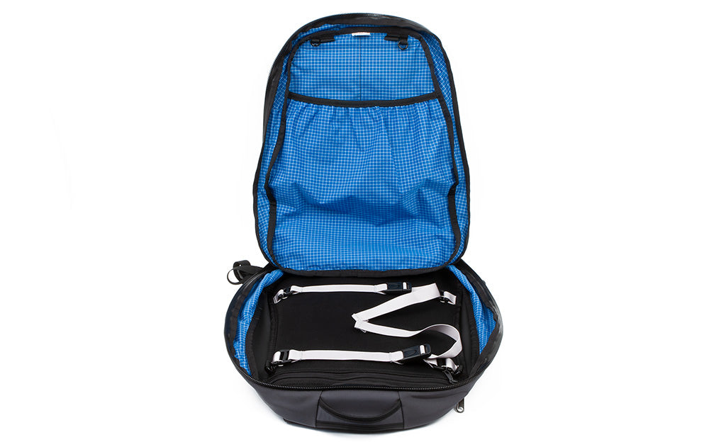 The clamshell opening of the Synik 30 opened showing the main compartment with included lash straps.