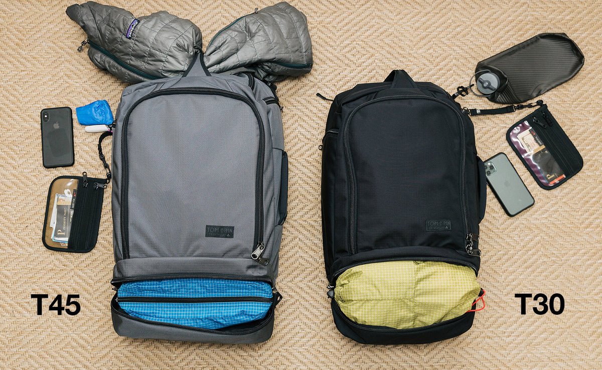 A comparison of what can fit in the Techonauts. The Techonaut 45 (left) has a puffy coat stowed in the top grab handle and a Packing Cube in it's bottom pocket. The Techonaut 30 (right) has a Aeronaut 30 Travel Stuff Sack in its bottom pocket.