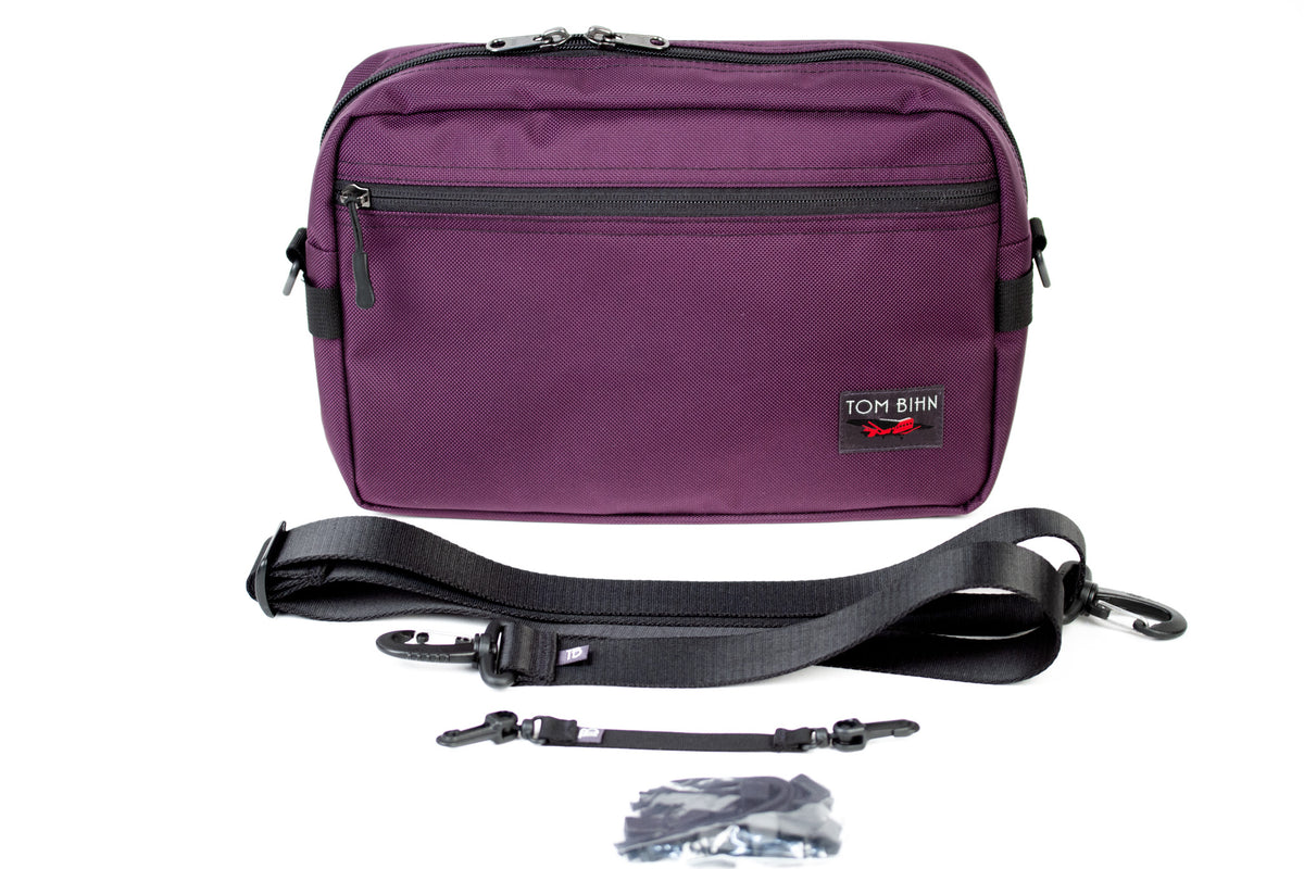 The Side Hustle and included items (1.5" shoulder strap, 8" black key strap, black cord zipper pulls).