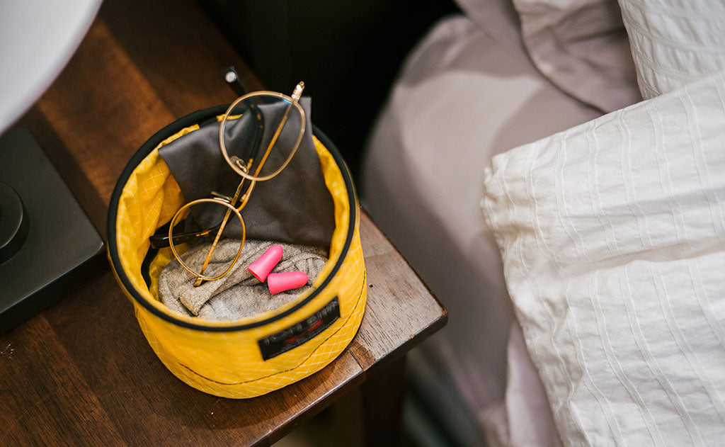 ^^A Large Travel Tray holding a eyeglass cleaning rag, glasses, earplugs, and a handtowel.