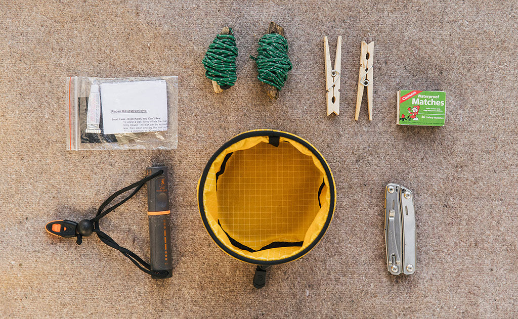 visible lifestyle ^^A Small Travel Tray with a possible loadout (including a few bolts of bungee cord, a couple clothespins, a box of matches, a knife, a portable flashlight, and a bag patch kit).