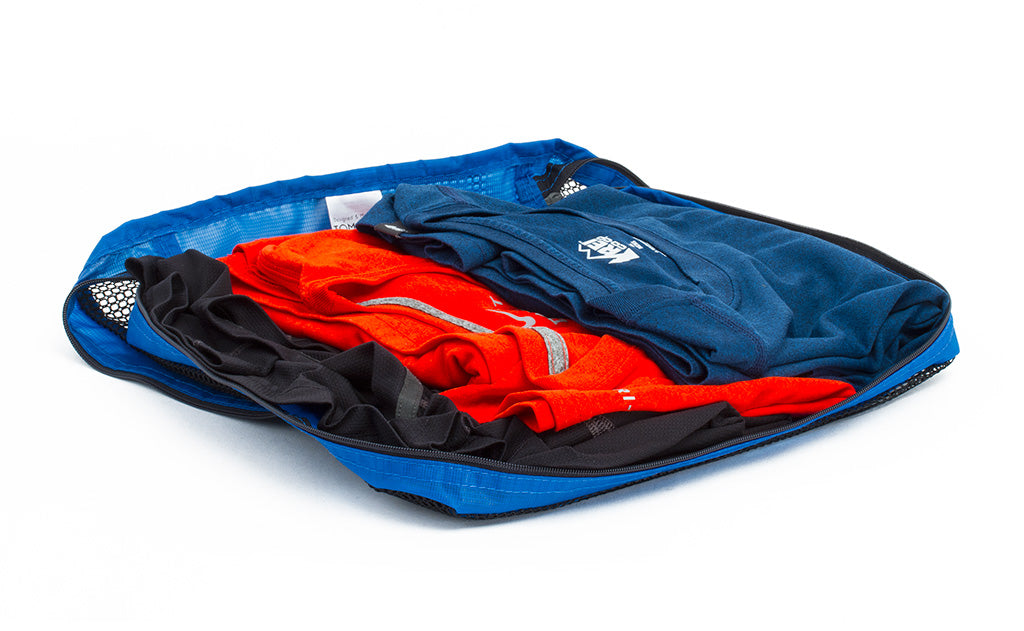 visible variant TB94002-LE^^An open Medium Tri-Star Packing Cube in Island (blue) 120 Aether filled with shirts.