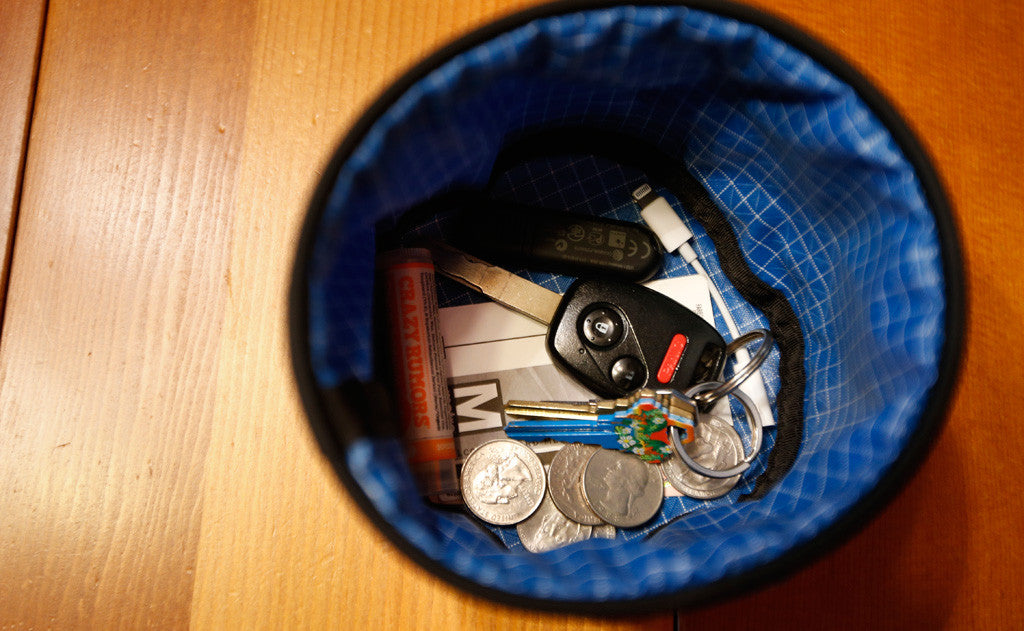 ^A Small Travel Tray holding some change, a keydrive, a dongle, a Metrocard, chapstick, and a pair of keys.