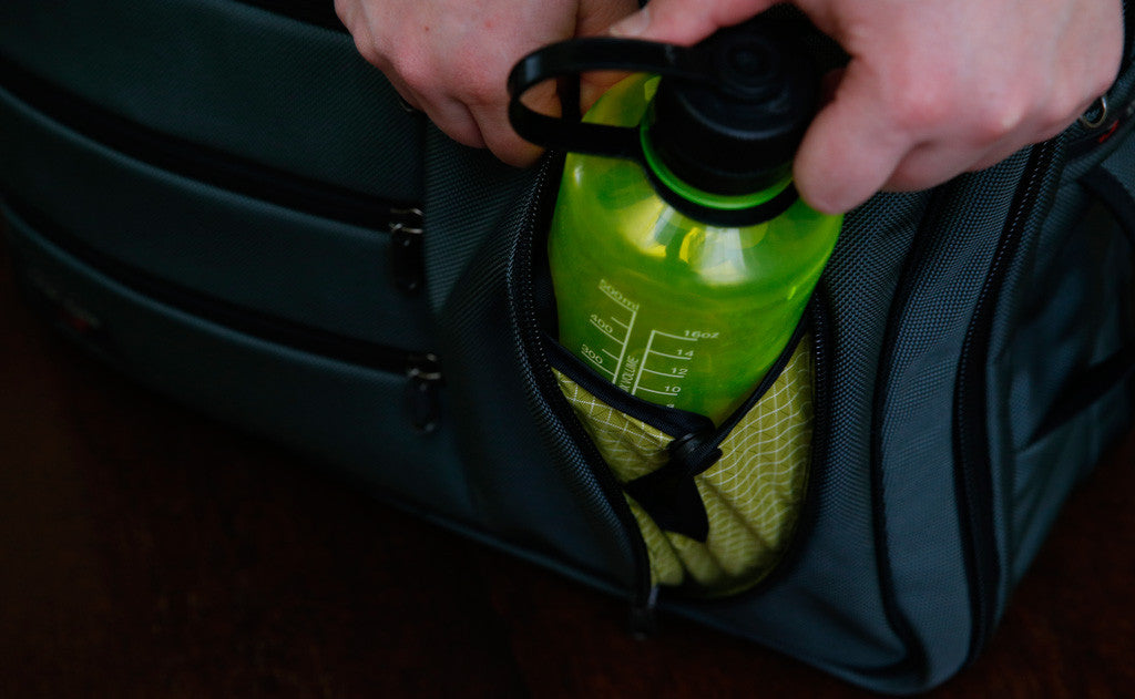 A 16 ounce water bottle being removed from the water bottle pouch on a Tri-Star.