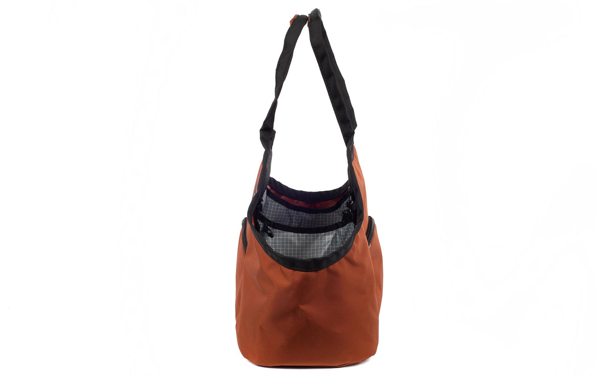 visible variant TB0619-TKND^^The Truckasana in Burnt Orange with Northwest Sky 200d Halcyon lining. Side view of the bag.