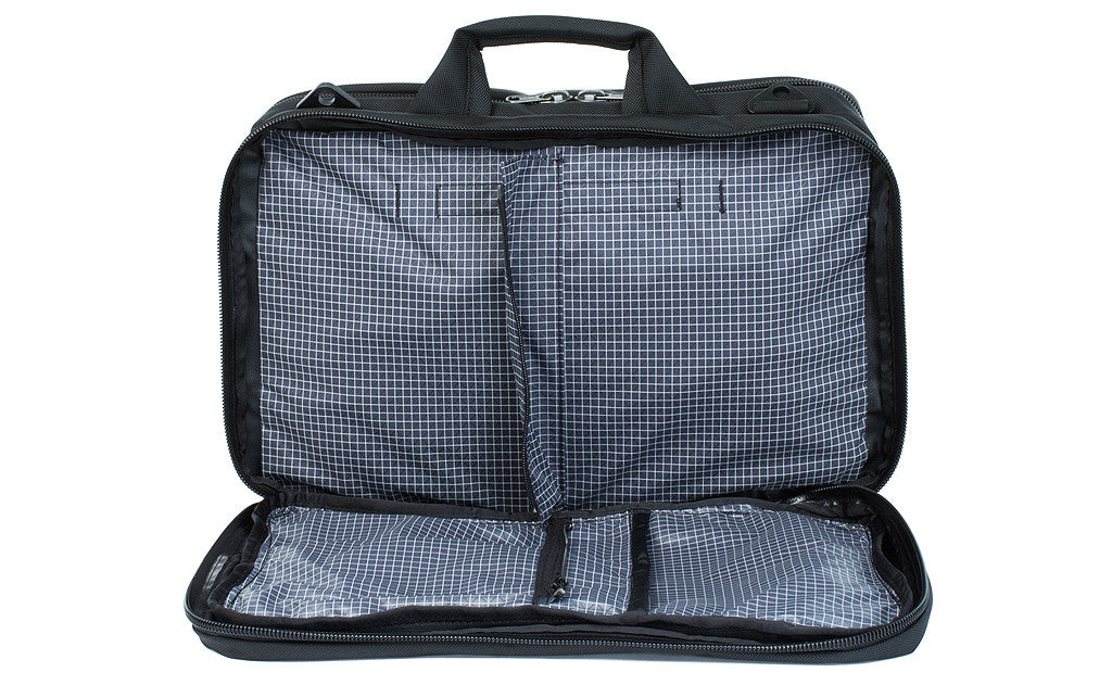 A front shot of the front pocket of a Black 525 Ballistic exterior open showing the Steel (dark grey) 200 Halcyon interior's zippered divider unzipped.