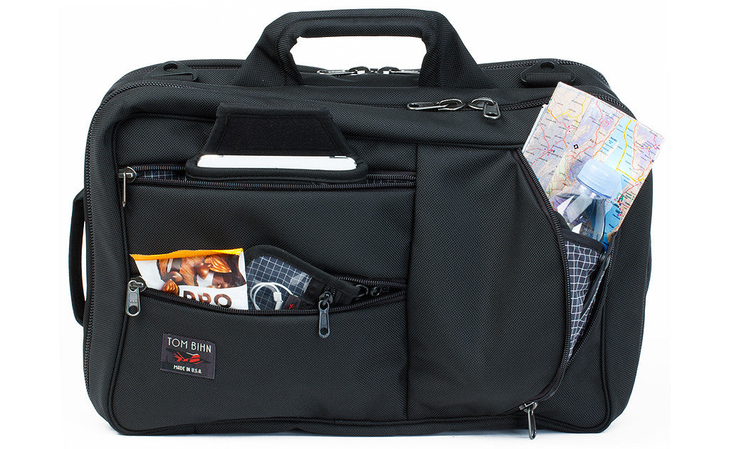 A front shot of the a Black 1050 Ballistic exterior Western Flyer with a map, tablet, snacks, and a pouch with cables in the front zippered pockets.