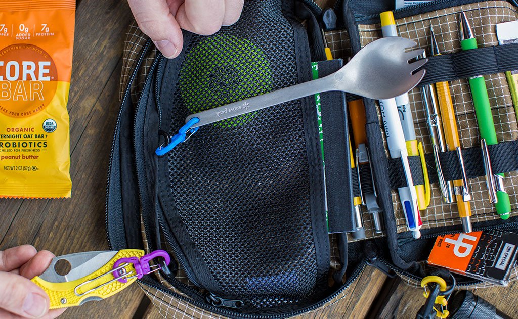 visible variant PT0573-OA PT0573-LA PT0573-UA^^A small double carabiner connecting a metal spork and anothe connecting a pocket knife, both to an Handy Little Thing.